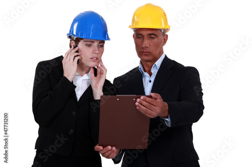 Photo: Architect and colleague looking at clip-board Architect and colleague looking at clip-board
