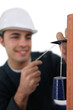 Mason using pendulum to check wall