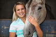 Blonde girl stroking horse