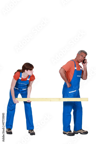 Photo: Two workers carrying wood Two workers carrying wood