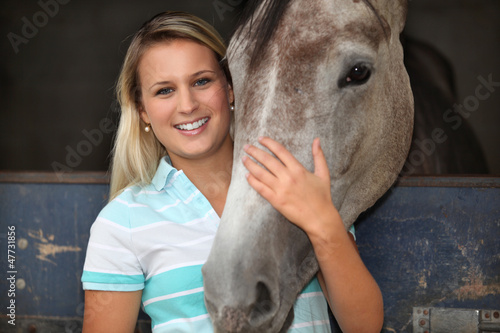 Photo: Blonde girl stroking horse Blonde girl stroking horse