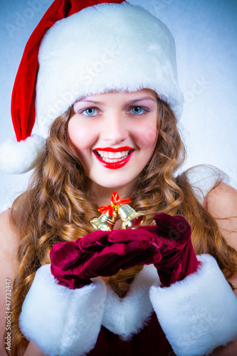 Photo: Beautiful woman in a red dress and hat of Santa with a christmas Beautiful woman in a red dress and hat of Santa with a christmas