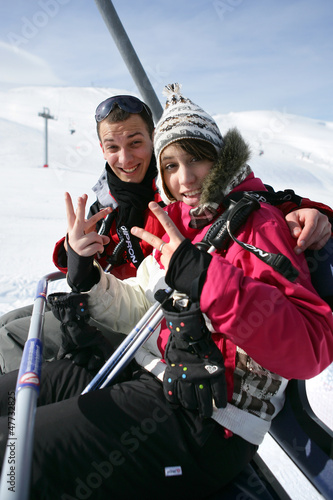 Photo: Young couple riding a ski lift Young couple riding a ski lift