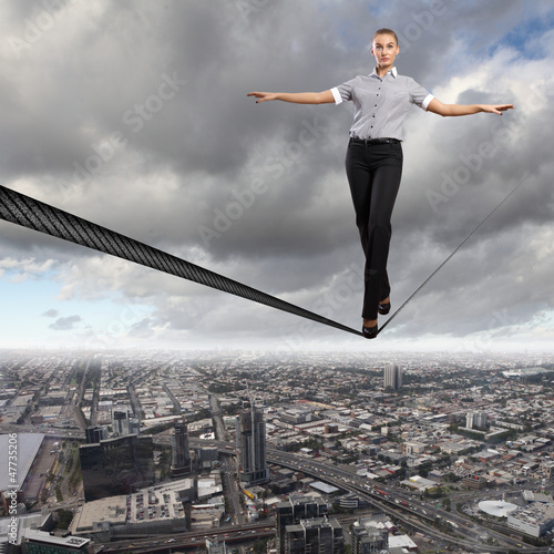 Photo: Balancing businesswoman and cityscape Balancing businesswoman and cityscape