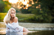 Sexy blonde woman play in lingerie in a river water.