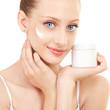Cute woman applying cream to her face