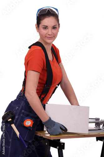 Photo: Woman cutting tile Woman cutting tile