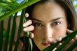 Woman hiding behind leaves