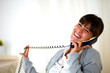 Happy laughing woman conversing on phone at home