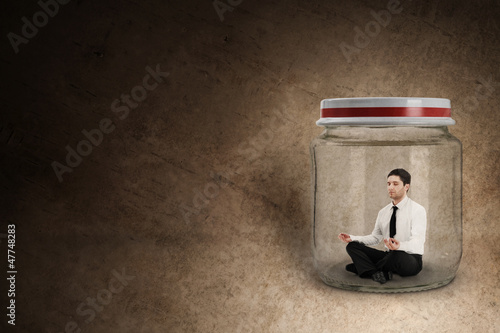 Photo: Businessman meditating in jar Businessman meditating in jar