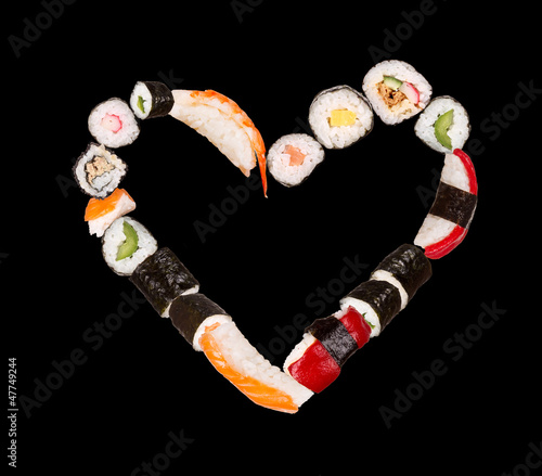 Photo: Pieces of sushi in heart shape, isolated on black background Pieces of sushi in heart shape, isolated on black background