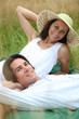 Photo: 40 years old man and woman relaxing and lying down in a meadow 40 years old man and woman relaxing and lying down in a meadow