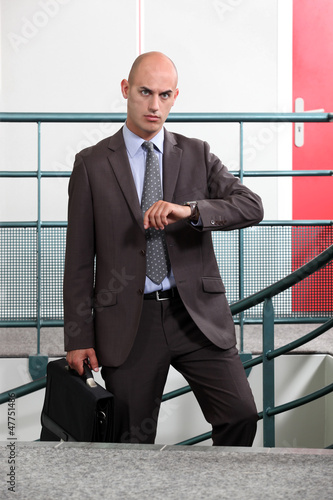 Photo: An angry businessman looking at the time An angry businessman looking at the time