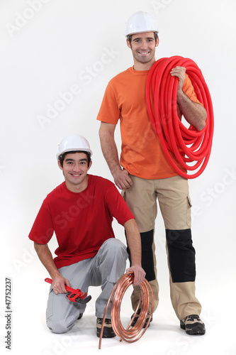 Photo: duo of cheerful plumbers duo of cheerful plumbers