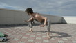 Man practices yoga on the roof. Squats.