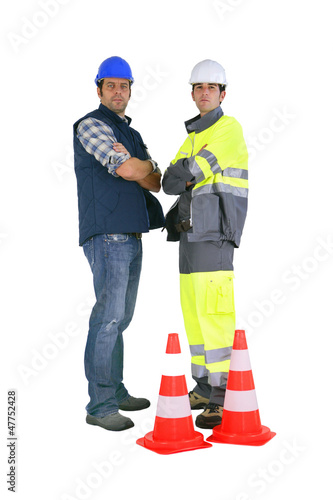 Photo: Two road workers stood by traffic cones Two road workers stood by traffic cones