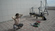 Man practices yoga on the roof. Squats hands behind his head.