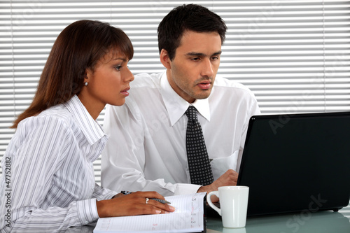 Photo: Business people looking at a laptop Business people looking at a laptop