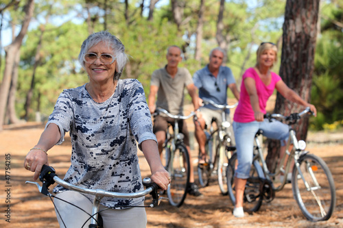 Photo: Senior woman and her friends riding bikes Senior woman and her friends riding bikes