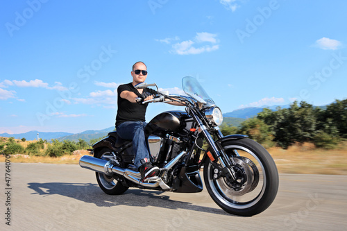 Photo: A young biker riding a customized motorcycle A young biker riding a customized motorcycle