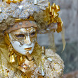 Person in Venetian costume attends Carnival of Venice.