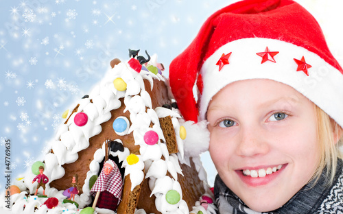 Photo: Mädchen mit Weihnachtsmütze und Pfefferkuchenhaus Mädchen mit Weihnachtsmütze und Pfefferkuchenhaus