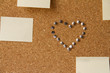 Heart made form pins on cork office board with papers