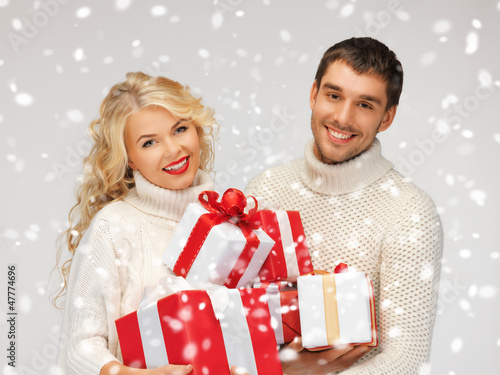 Photo: family couple in a sweaters with gift boxes family couple in a sweaters with gift boxes