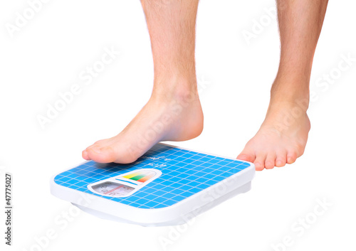 Photo: Man's legs ,which weighed on floor scale. Isolated Man's legs ,which weighed on floor scale. Isolated