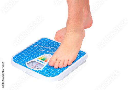 Photo: Man's legs ,which weighed on floor scale. Isolated Man's legs ,which weighed on floor scale. Isolated
