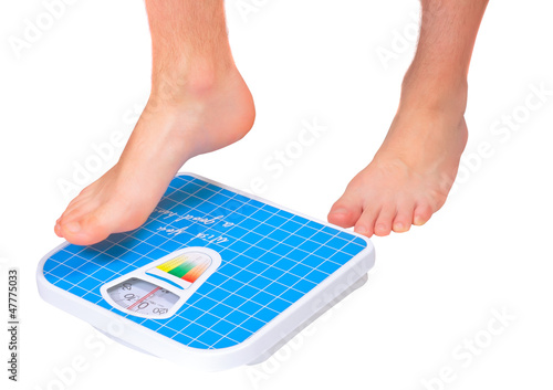 Photo: Man's legs ,which weighed on floor scale. Isolated Man's legs ,which weighed on floor scale. Isolated