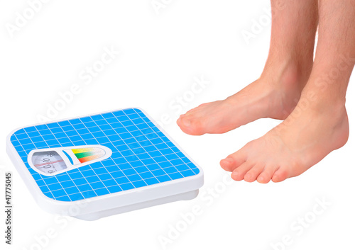 Photo: Man's legs ,which weighed on floor scale. Isolated Man's legs ,which weighed on floor scale. Isolated