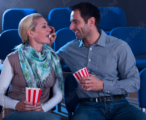 Photo: Loving couple sharing their popcorn Loving couple sharing their popcorn