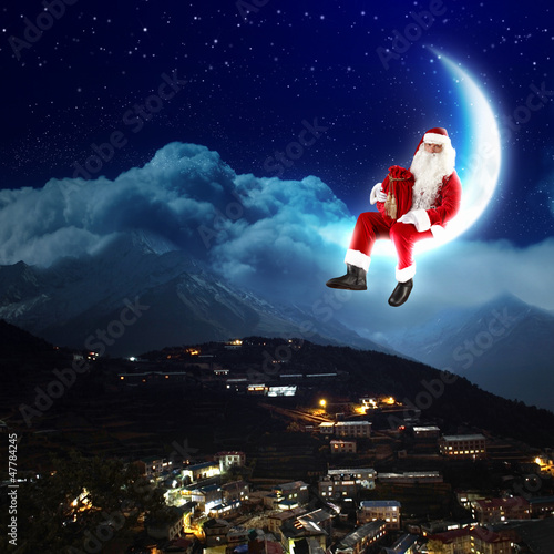 Photo: photo of santa claus sitting on the moon photo of santa claus sitting on the moon