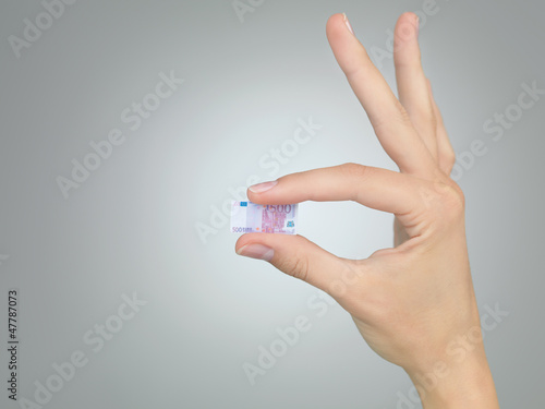 Photo: female hand with tiny money female hand with tiny money