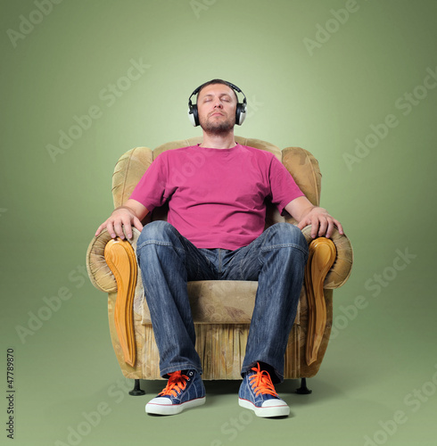 Photo: Man listening to relaxing music while sitting in a chair Man listening to relaxing music while sitting in a chair