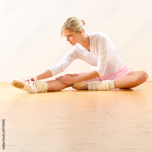 Photo: Beautiful ballet dancer stretching in the studio Beautiful ballet dancer stretching in the studio