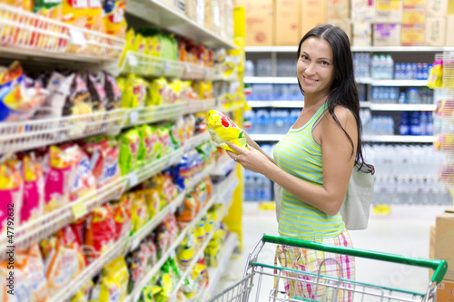 Photo: Woman buys potato chips in the store Woman buys potato chips in the store