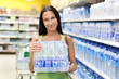 A woman buys a bottle of water in the store