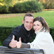 Happy young couple giving a thumbs up