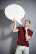 Happy man holding empty speech balloon.