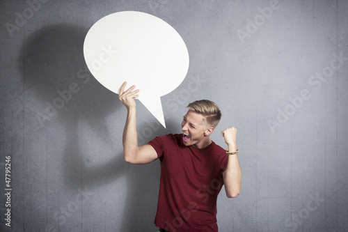 Photo: Successful man holding empty speech balloon. Successful man holding empty speech balloon.