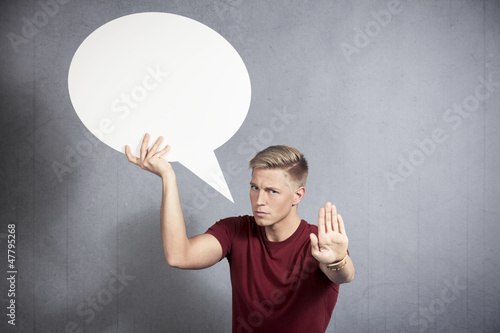 Photo: Warning man holding blank speech bubble making stop gesture. Warning man holding blank speech bubble making stop gesture.