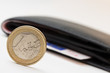 Euromünze mit Geldbörse im Hintergrund