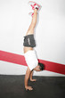 A man does a gymnastic handstand in the gym