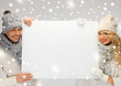 couple in a winter clothes holding blank board