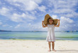 Photo: young happy child girl in summer hat on tropical sea background young happy child girl in summer hat on tropical sea background