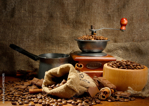 Photo: Coffee grinder, turk and cup of coffee on burlap background Coffee grinder, turk and cup of coffee on burlap background