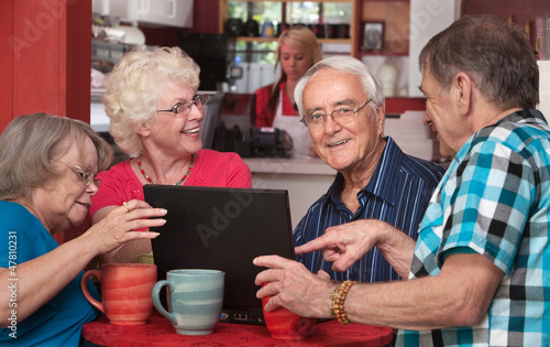 Photo: Seniors Having Fun with Computer in Cafe Seniors Having Fun with Computer in Cafe