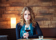 Photo: Portrait of pretty girl in restaurant holding glass with wine Portrait of pretty girl in restaurant holding glass with wine